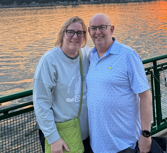 Un groupe d’hommes sourit et fait signe à la caméra.